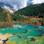 Autumn view of Huanglong National Park with dark blue ponds