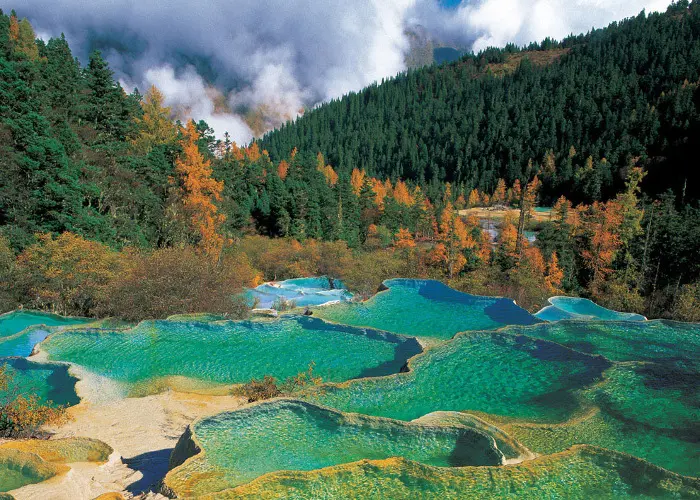Autumn view of Huanglong National Park with dark blue ponds