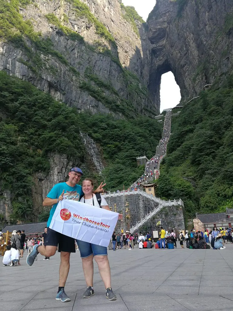 WindhorseTour travelers posing in front of the famous Tianmen Cave, also known as Heaven’s Gate, at Tianmen Mountain in Zhangjiajie, China