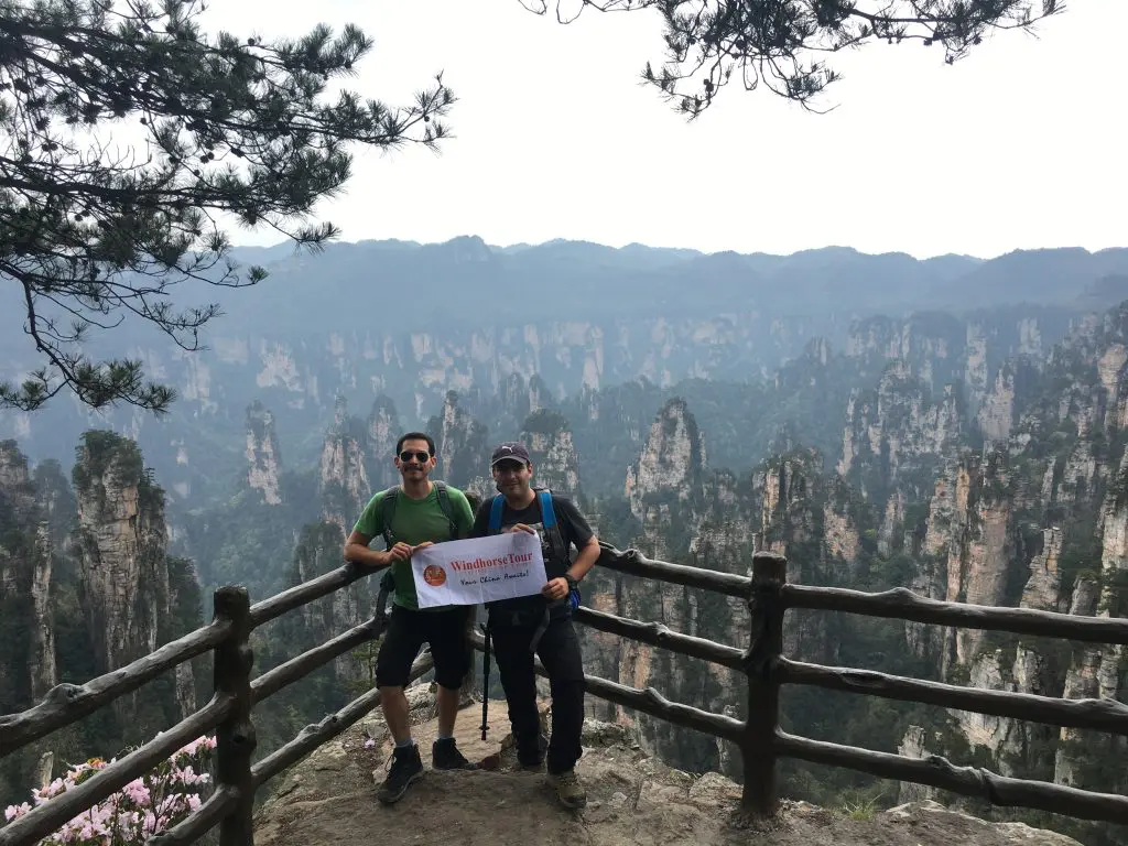 WindhorseTour travelers enjoying the summer scenery at Tianzi Mountain in Zhangjiajie, surrounded by towering sandstone pillars and lush green peaks in China