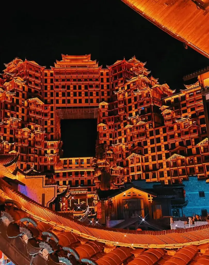 Evening view of 72 Qilou featuring traditional Tujia-style architecture and illuminated towers