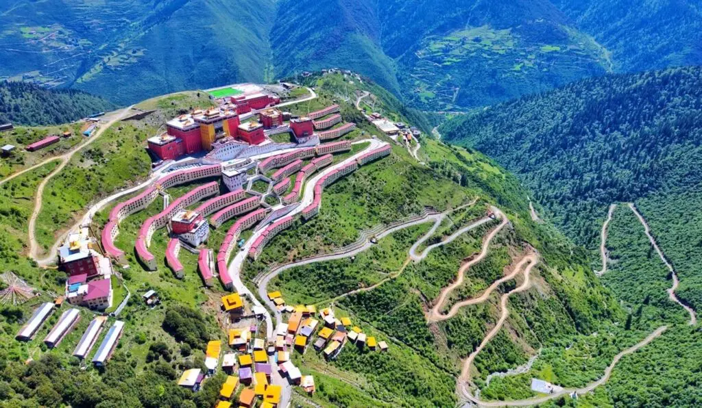 Katok Monastery in Ganzi, a sacred Tibetan monastery in the Kham region of Western Sichuan, surrounded by rolling hills and prayer flags.