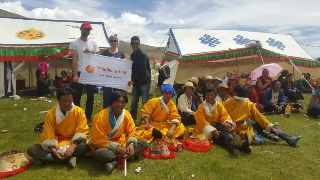 WindhorseTour Tibetan guide Jampa Wangdue leading travelers at a local festival in Tibet