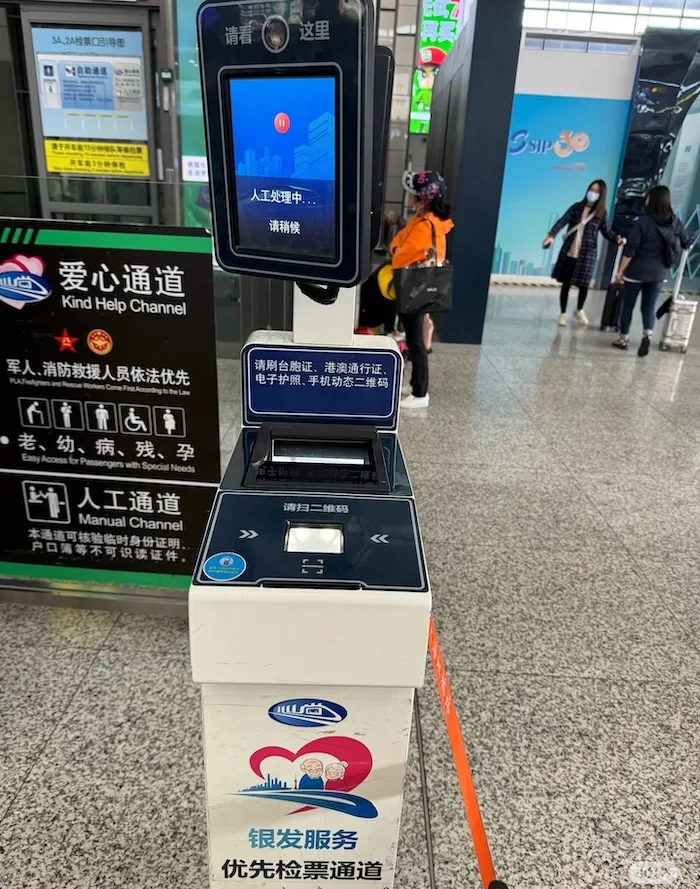Close-up of a modern blue-lit automated gate at a Chinese train station featuring a dedicated passport scanner window.
