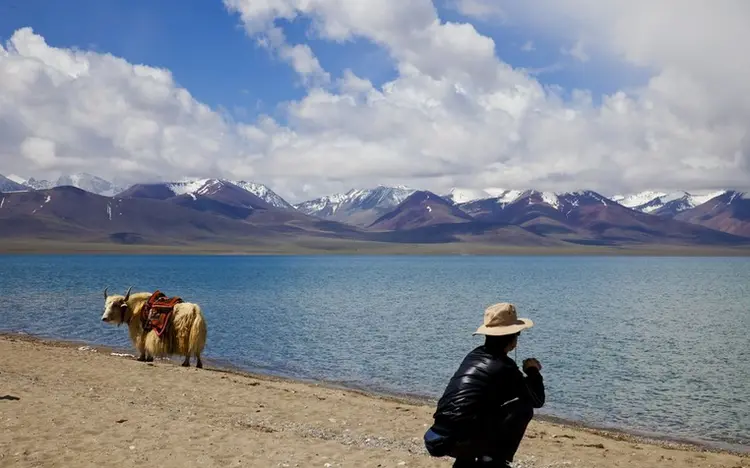 Namtso Lake in Tibet with clear blue water and the snow-capped Nyenchen Tanglha range behind